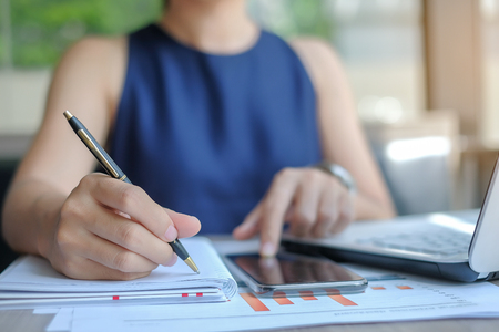 Businesswoman using smatphone for analysis maketing plan, Manager calculate financial report and graph chart.  Business, Finance and Accounting conceptsの写真素材