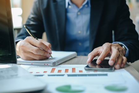 Businessman using smatphone for analysis maketing plan, Manager calculate financial report and graph chart.  Business, Finance and Accounting conceptsの写真素材
