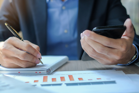 Businessman using smatphone for analysis maketing plan, Manager calculate financial report and graph chart.  Business, Finance and Accounting conceptsの写真素材