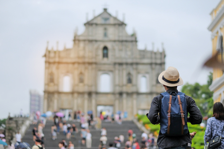Young man traveling backpacker with hat, Asian hipster traveler looking to Ruins of St. Paul's, Historic Centre of Macauの写真素材