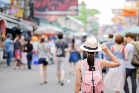 Young Woman traveling with hat, Asian hipster traveler walking at famous backpacker street in Bangkok (Khao San road), landmark and popular for tourist attractions in Thailand. Travel conceptの写真素材