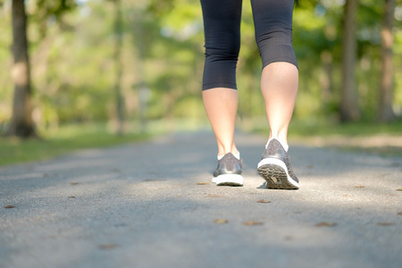 young fitness woman legs walking in the park outdoor, female runner running on the road outside,...