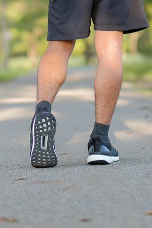 young fitness man legs walking in the park outdoor, male runner running on the road outside, asian...