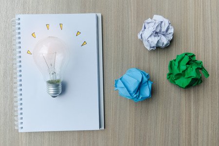 light bulb or lamp with colorful crumpled paper on wooden table. New Idea, Creative, Genius and Innovation conceptsの写真素材