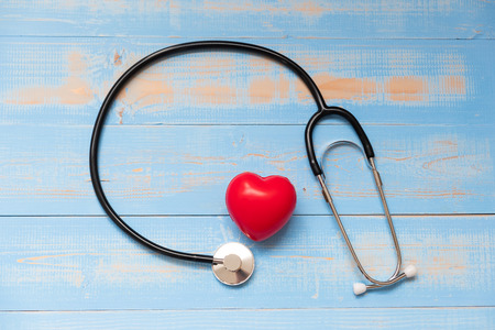 Stethoscope with Red heart shape on blue pastel color wooden background. Healthcare and Insurance conceptの写真素材