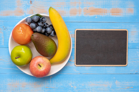 green apple, red apple, Avocado, orange, banana and grape on blue wooden background. World Food Day Concept (October 16), Top view and Copy space for your textの写真素材