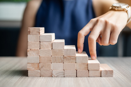 Businesswoman finger step on wooden block building. Business planning, Risk Management, Solution and strategy Conceptsの写真素材