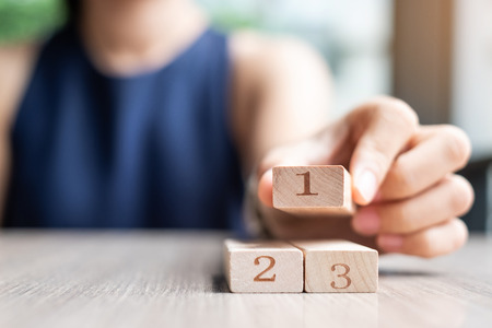 Businesswoman hand placing or pulling 1 st wooden block on the building. Business planning, Risk Management, Solution and strategy Conceptsの写真素材