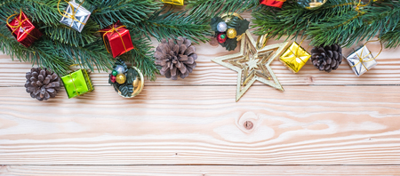 Christmas background with decoration, gift box, Star shape, Bell and pine tree branches on wooden board, Happy New Year and Xmas Holidays banner. Top view and Copy Space for your textの写真素材