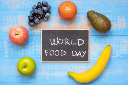 green apple, red apple, Avocado, orange, banana and grape on blue wooden background. World Food Day Concept (October 16), Top view and Copy space for your textの写真素材