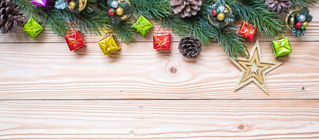 Christmas background with decoration, gift box, Star shape, Bell and pine tree branches on wooden board, Happy New Year and Xmas Holidays banner. Top view and Copy Space for your textの写真素材