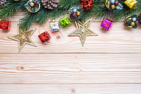 Christmas background with decoration, gift box, Star shape, Bell and pine tree branches on wooden board, Happy New Year and Xmas Holidays banner. Top view and Copy Space for your textの写真素材