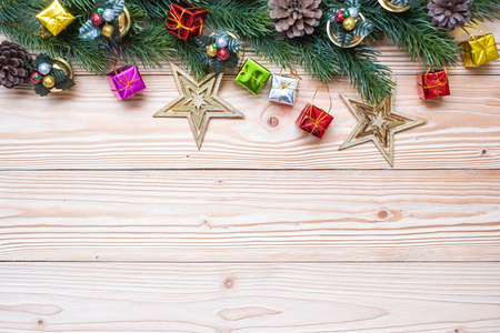 Christmas background with decoration, gift box, Star shape, Bell and pine tree branches on wooden board, Happy New Year and Xmas Holidays banner. Top view and Copy Space for your textの写真素材