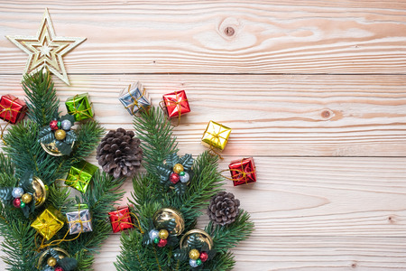 Christmas background with decoration, gift box, Star shape, Bell and pine tree branches on wooden board, Happy New Year and Xmas Holidays banner. Top view and Copy Space for your textの写真素材