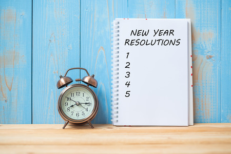 New years Resolutions text on notebook and retro alarm clock  on table and copy space. Goals, Mission and New Start Conceptの写真素材