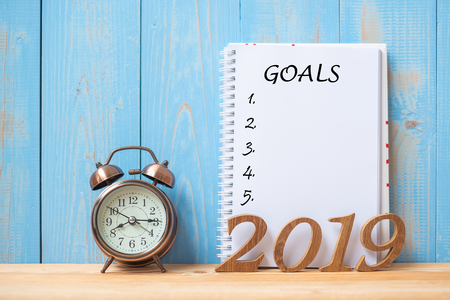 2019 Happy New years with Goals text on notebook, retro alarm clock and wooden number on table and copy space. Resolution, Mission and New Start Conceptの写真素材