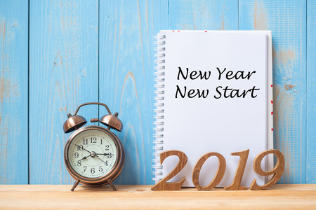 2019 Happy New year New Start Text on notebook, retro alarm clock and wooden number  on table and copy space. Resolution, Goals and Mission Conceptの写真素材