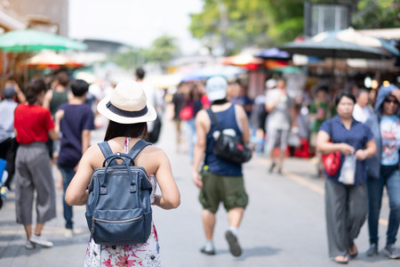 woman traveling backpacker with hat, Asian traveler standing at Chatuchak Weekend Market, landmark and popular for tourist attractions in Bangkok, Thailand. Travel conceptの写真素材