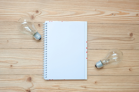 blank notebook with lightbulb and crumbled paper on wooden table, Top view and copy space. Idea, Creative, Innovation, Solution, Strategy, Goals and Mission conceptの写真素材