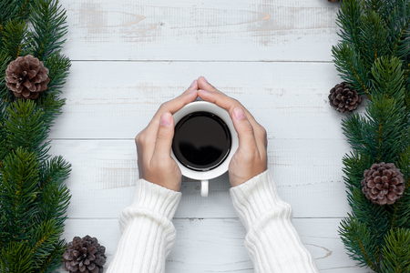 woman hand holding black coffee cup with Christmas decoration, Happy New Year and Xmas Holidaysの写真素材