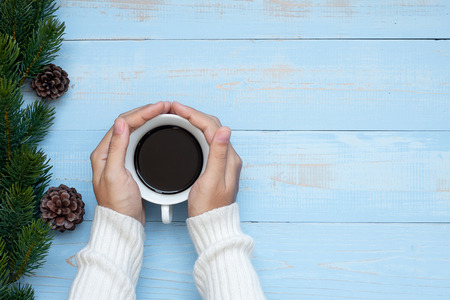woman hand holding black coffee cup with Christmas decoration, Happy New Year and Xmas Holidaysの写真素材