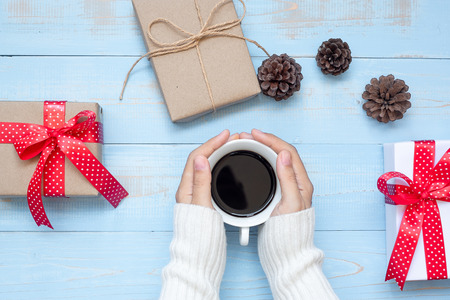 woman hand holding black coffee cup with Christmas decoration, Happy New Year and Xmas Holidaysの写真素材