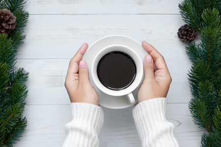 woman hand holding black coffee cup with Christmas decoration, Happy New Year and Xmas Holidaysの写真素材