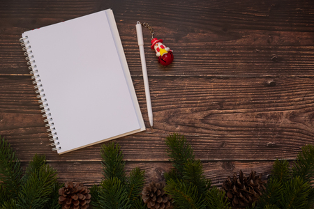 blank notebook with Christmas decoration, gift box and pine tree branches on wooden background, preparation for holiday concept, Happy New Year and Xmas Holidays. Top view and Copy Space for textの写真素材