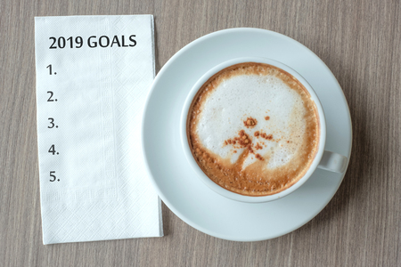2019 GOALS word with hot cappuccino coffee cup on table background at the morning. New Year New Start, Resolution, Solution, Strategy and Mission conceptの写真素材