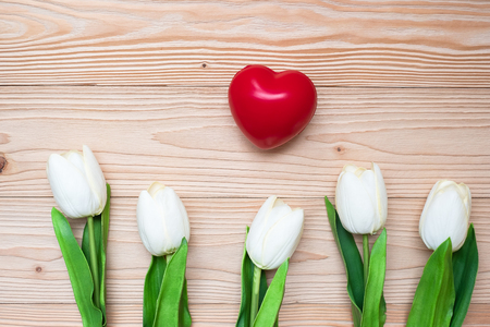 Top view white tulip flowers with red heart shape on wooden table. love, romantic and Valentine Day holiday Conceptの写真素材
