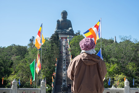 woman traveling with hat, Asian traveler visit the Tian Tan or Big Buddha located at Po Lin Monastery in Ngong Ping Lantau Island. landmark and popular for tourist attractions in Hong Kongの写真素材