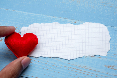 blank  paper note with red heart shape decoration on blue wooden table background. Wedding, Romantic and Happy Valentineâ s day holiday conceptの写真素材