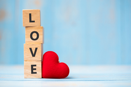 LOVE wooden cubes with red heart shape decoration on blue table background and copy space for text. Love, Romantic and Happy Valentineâs day holiday conceptの写真素材