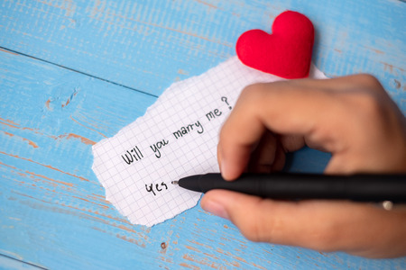 WILL YOU MARRY ME? word on paper note on blue wooden table background. Wedding, Romantic and Happy Valentineâ s day holiday conceptの写真素材