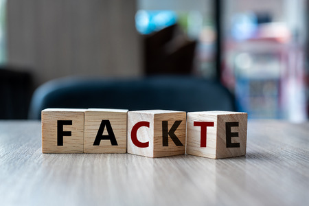 wooden cube with flip over block FAKE to FACT word on table background. News, solution and business  conceptsの写真素材