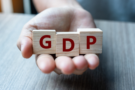 Business man hand holding wooden cube with GDP text (Gross domestic product) on table background. Financial, Management and business conceptsの写真素材