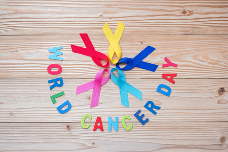 World cancer day (February 4). colorful awareness ribbons; blue, red, pink and yellow color on wooden background  for supporting people living and illness. Healthcare and medicine conceptの写真素材