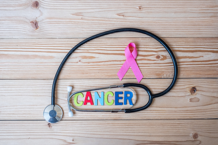 World cancer day (February 4) or Breast cancer and pink ribbon on wooden background with stethoscpoe for supporting people living and illness. Healthcare and medicine conceptの写真素材