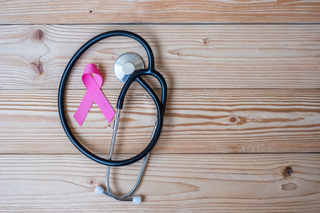 World cancer day (February 4) or Breast cancer and pink ribbon on wooden background with stethoscpoe for supporting people living and illness. Healthcare and medicine conceptの写真素材