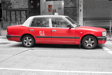 red and white colors Taxi cab, symbol of HK, on Hollywood road near Central and Sheung Wan districtの写真素材