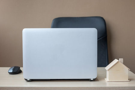 wooden House model and computer laptop on table. housing purchase, Property, real estate and business conceptsの写真素材