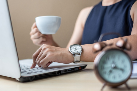 young Businesswoman using laptop analysis marketing plan and drinking coffee in the morning. Business, Finance and lifestyle conceptsの写真素材