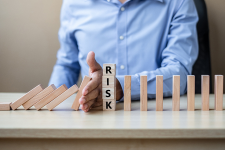 Businessman hand Stopping Falling wooden Blocks or Dominoes. Business, Risk Management, Solution, Insurance and strategy Conceptsの写真素材