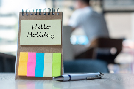 Hello Holiday text on note paper or empty reminder template on wooden table. New Goal New Start conceptの写真素材