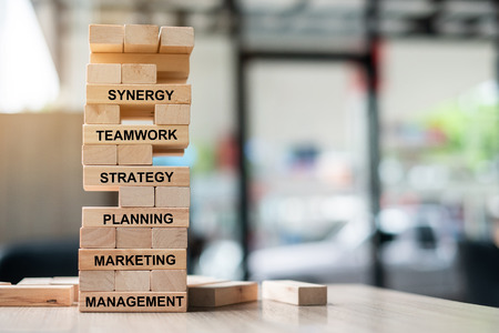 wooden tower building with text; Synergy, Teamwork, Strategy, Planning, Marketing and Management. Business Conceptsの写真素材
