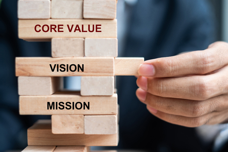 Businessman hand placing or pulling wooden block on the tower. Business planning, Risk Management, Solution, Mission, Vision, Core values  and strategy Conceptsの写真素材