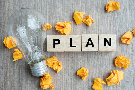 PLAN text wood cube and crumbled paper with lightbulb on wooden table background. IDEA, Creative, Innovation, Imagination, inspiration, Solution, Strategy and GOAL conceptの写真素材