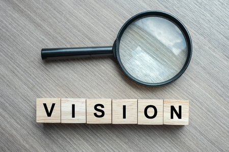 Vision text wooden cubes and magnifying glass on wood table background. SEO, Idea, Strategy, Analysis, goals and Values conceptの写真素材