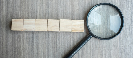 empty wooden cubes and magnifying glass on wood table background. search, vision, Idea, Strategy, Analysis, goals and Values conceptの写真素材