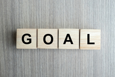 wooden cube with GOAL text on table background. success, strategy, solution and business conceptsの写真素材